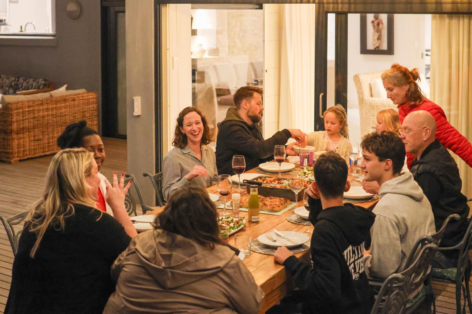 Family and friends enjoying dinner outdoors at Spindrift Villa - nox Rentals