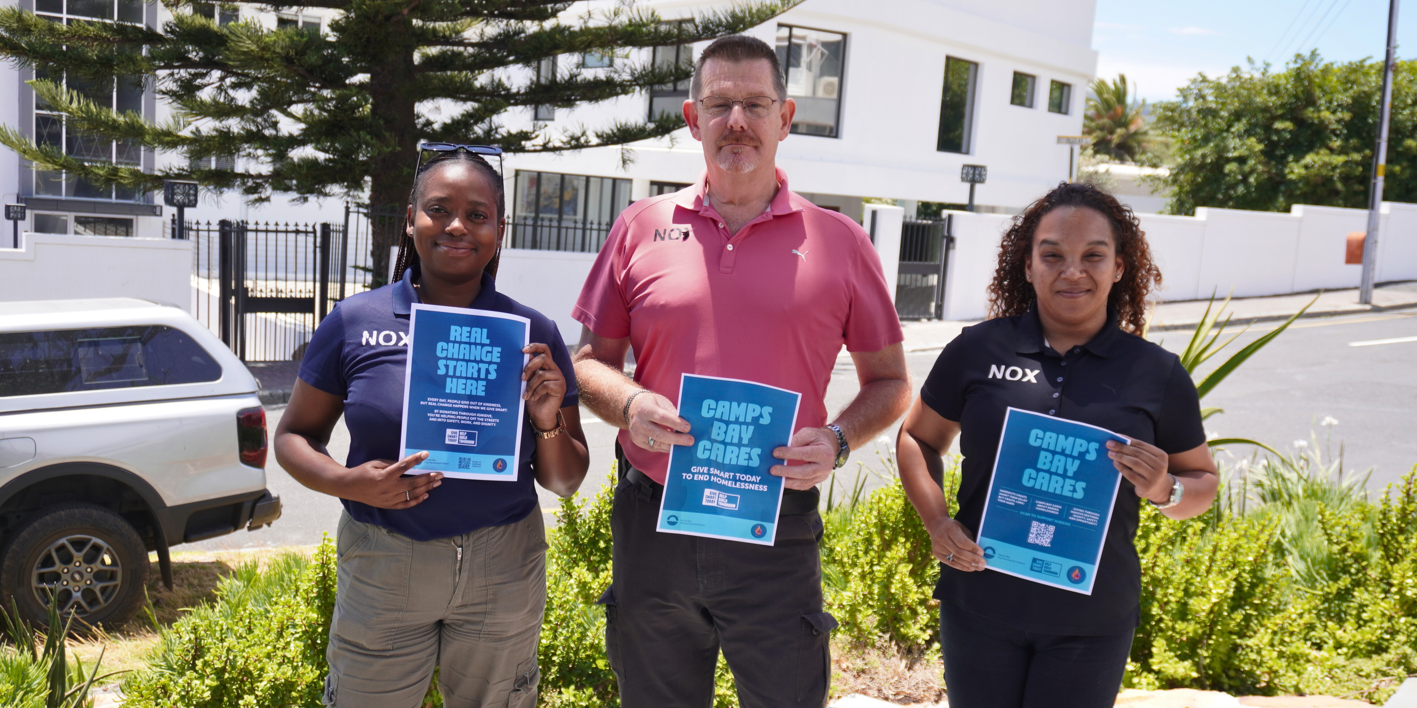 Nox Staff holding 'Camps Bay Cares' Posters